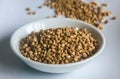 Raw organic Buckwheat in ceramic bowl on white plate