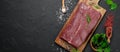 Raw organic marbled beef with spices on a wooden cutting board on a black slate, stone or concrete background Royalty Free Stock Photo