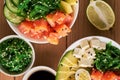 Raw Organic Poke Bowl with rice, avocado, salmon, mango, cucumbers, chuka salad, quail eggs, sweet onions with soy sauce and chuka Royalty Free Stock Photo