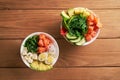 Raw Organic Poke Bowl with with rice, avocado, salmon, mango, cucumbers, chuka salad, quail eggs, sweet onions two plates close-up Royalty Free Stock Photo