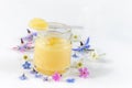 Raw organic royal jelly in a small bottle with litte spoon on small bottle on white background