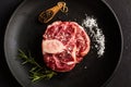 Raw osso buco on a black plate