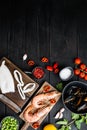 Raw paella ingredients on black wooden surface, top view with space for text