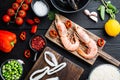 Raw paella ingredients over black wooden table, top view