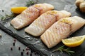 Raw pangasius fish fillet served with lemon and seasoning