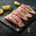 Raw pangasius fish fillet served with lemon and seasoning