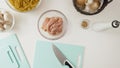 Raw pasta, chopped chicken fillet, mushrooms, onion and garlic. Ingredients close up on white background