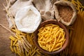 Raw pasta with flour, wheat ears and grains, top view Royalty Free Stock Photo