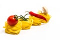 Raw pasta, fresh vegetables, tomatoes and mushrooms on a white background Royalty Free Stock Photo