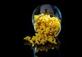 raw pasta in glass jar, wine glass. in bucket. raw pasta on black background. front view raw pasta, dropped from hand, place for Royalty Free Stock Photo