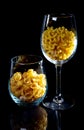 raw pasta in glass jar, wine glass. in bucket. raw pasta on black background. front view raw pasta, dropped from hand, place for Royalty Free Stock Photo