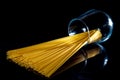 raw pasta in glass jar, wine glass. in bucket. raw pasta on black background. front view raw pasta, dropped from hand, place for Royalty Free Stock Photo