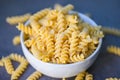 Raw pasta macaroni on white bowl, close up raw macaroni spiral pasta uncooked delicious fusilli pasta for cooking food Royalty Free Stock Photo