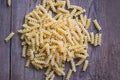 Raw pasta macaroni on wooden background, close up raw macaroni spiral pasta uncooked delicious fusilli pasta for cooking food Royalty Free Stock Photo