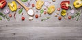 Raw pasta with peppers and cherry tomatoes with a wooden spoon and salt on a long gray wooden background top view place for text,f