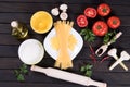 Raw pasta, tomatoes,mushrooms, flour and egg on black wooden table background Royalty Free Stock Photo