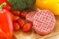 Raw patties of minced meat on a wooden board