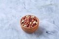 Raw peanuts mix in ceramic bowl isolated over white textured backround, top view, close-up. Royalty Free Stock Photo
