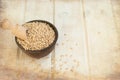 Raw pearl barley in a bowl and wooden spoon