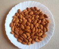 Raw peeled almond grains on a white plate