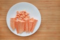 Raw peeled and chopped sweet potatoes in white plate on wood board background with copy space Royalty Free Stock Photo