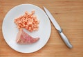 Raw peeled and chopped sweet potatoes in white plate on wood board background with sharp knife Royalty Free Stock Photo