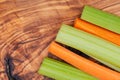 Raw peeled and cut Organic Celery Stalks and Orange Carrots arranged on olive wood. Apiaceae or Umbelliferae family. Delic