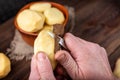 Raw peeled potatoes in bowl on dark wooden background Royalty Free Stock Photo