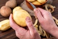 Raw peeled potatoes in bowl on dark wooden background Royalty Free Stock Photo