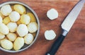 Raw peeled potatoes on old cutting board and kitchen knife close-up view from above Royalty Free Stock Photo