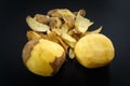 Raw peeled potatoes and potato peelings Royalty Free Stock Photo