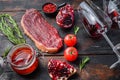 Raw picanha beef steak with rosemary, spicy chili oil, pomegranate and glass of red wine, on old dark wooden table side view, Royalty Free Stock Photo