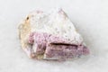 Raw pink Tourmaline in feldspar on white marble
