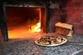 Raw pizza lay down stove with the fire on blade. Royalty Free Stock Photo