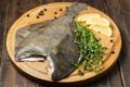 Raw plaice with pepper, thyme and lemon on the board