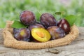 Raw plum on old wooden table with green background Royalty Free Stock Photo