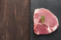 Raw pork on blackboard on wooden background