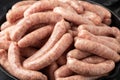 Raw pork chipolata sausage in cast iron skillet frying pan Royalty Free Stock Photo