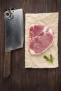 Raw pork chop steak and cleaver on wooden background Royalty Free Stock Photo