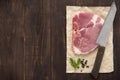 Raw pork chop steak and cleaver on wooden background Royalty Free Stock Photo