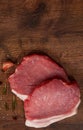 Raw pork chop steak and garlic, pepper on the brown wooden table background. rustic kitchen table with copy space. Royalty Free Stock Photo