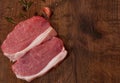 Raw pork chop steak and garlic, pepper on the brown wooden table background. rustic kitchen table with copy space. top view. Royalty Free Stock Photo