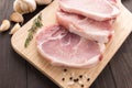 Raw pork chop steak and garlic, pepper on wooden background