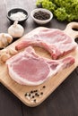 Raw pork chop steak and garlic, pepper on wooden background Royalty Free Stock Photo