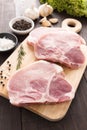 Raw pork chop steak and garlic, pepper on wooden background Royalty Free Stock Photo