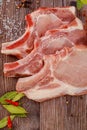 Raw pork chops bone in isolated on wooden background. Royalty Free Stock Photo