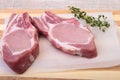 Raw pork chops, spices and rosemary on cutting board. Ready for cooking. Royalty Free Stock Photo