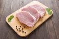 Raw pork on cutting board on wooden background. Royalty Free Stock Photo