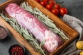 Raw pork fillet tenderloin. Fresh meat with ingredients and herbs for grill or baking, sage, potatoe, in wooden box, on gray stone Royalty Free Stock Photo