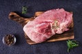 Raw pork ham, salt and rosemary on a cutting board on a dark background. Top view Royalty Free Stock Photo